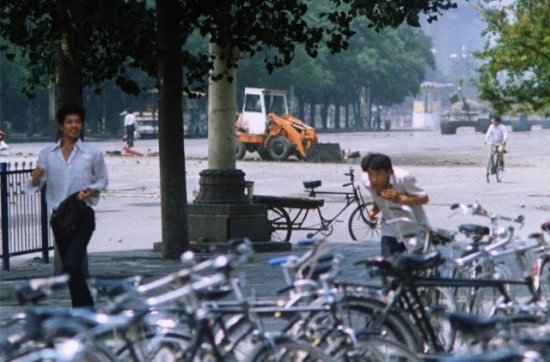 Another, recently unearthed photo of the Tank Man incident, which shows a new angle of his act of protest, now at a distance. Tank Man can be seen through the trees on the left, and the tanks can be seen on the far right.