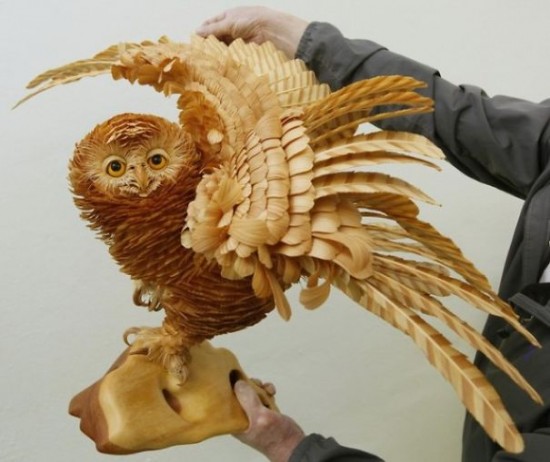 Artist Bobkov, shows a sculpture of a life-sized owl made from cutting chips from the Siberian cedar at an exhibition of his works in Kozhany