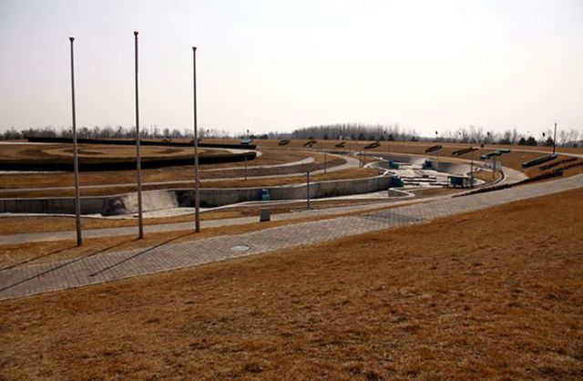 The flag poles used for medal ceremonies stand next to the former course for the kayaking competition of the 2008 Beijing Olympic Games, located on the outskirts of Beijing