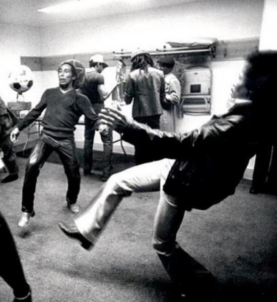Bob Marley goofing around with a soccer ball before playing a show