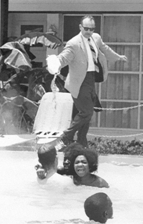Hotel owner pouring acid in the pool while black people swim in it, ca. 1964