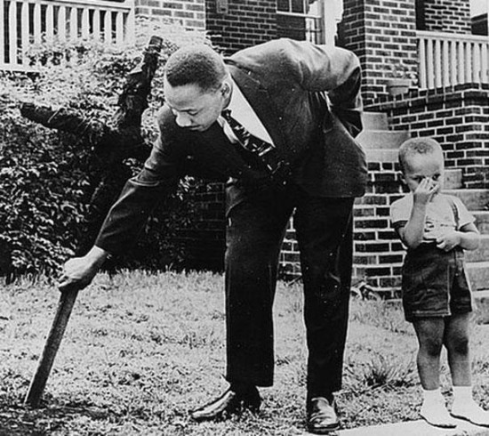 Martin Luther King with his son removing a burnt cross from their front yard, 1960