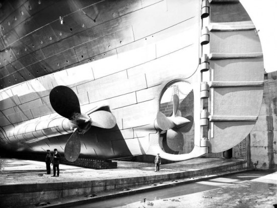 The Titanic in dry dock. Here you can see the scale of the person standing next to one of the propellers, 1912
