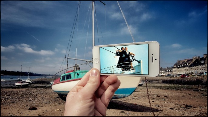 Movie and TV scenes on an iPhone held up in front of perfect real-life backgrounds 002