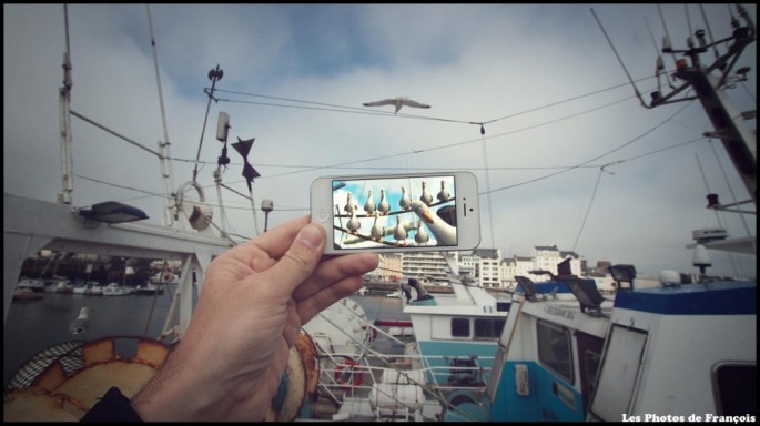 Movie and TV scenes on an iPhone held up in front of perfect real-life backgrounds 008