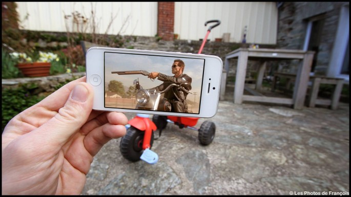 Movie and TV scenes on an iPhone held up in front of perfect real-life backgrounds 019